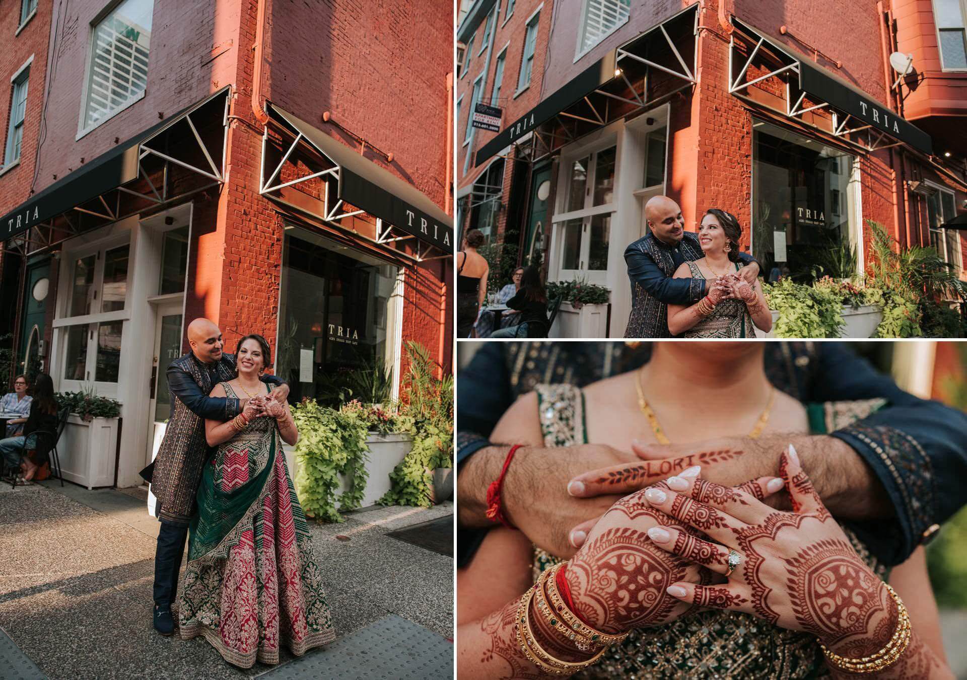 Groom embracing bride as they take photos outside of cafe Tria in Rittenhouse Square Park Philadelphia.  Bride shows off her mehndi. 