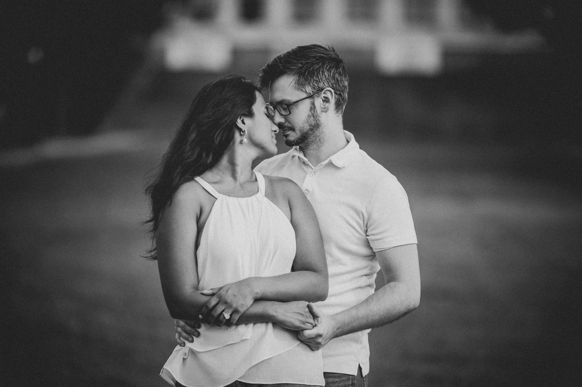 Black and white portrait of Swetha and Jason nose to nose behind the Philadelphia Art Museum at golden hour